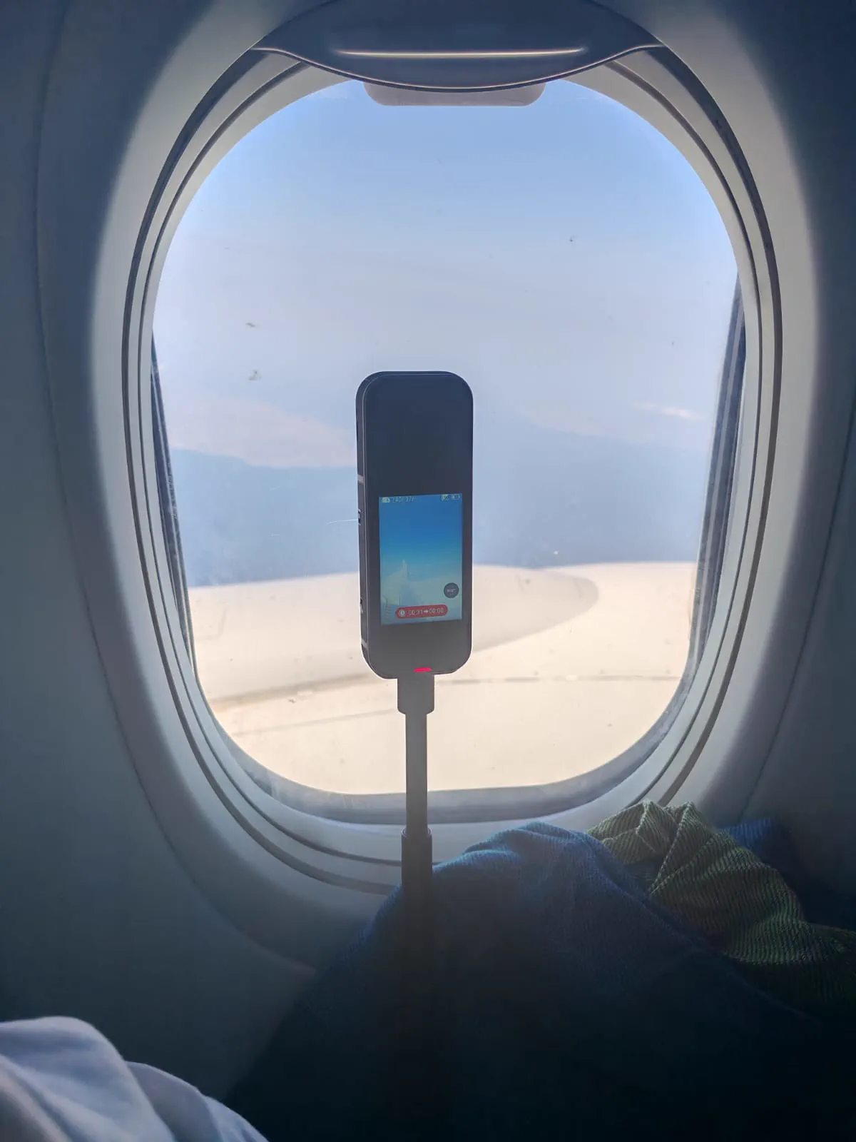 A 360 camera on a stick filming the aircraft wing from the window while leaving Athens