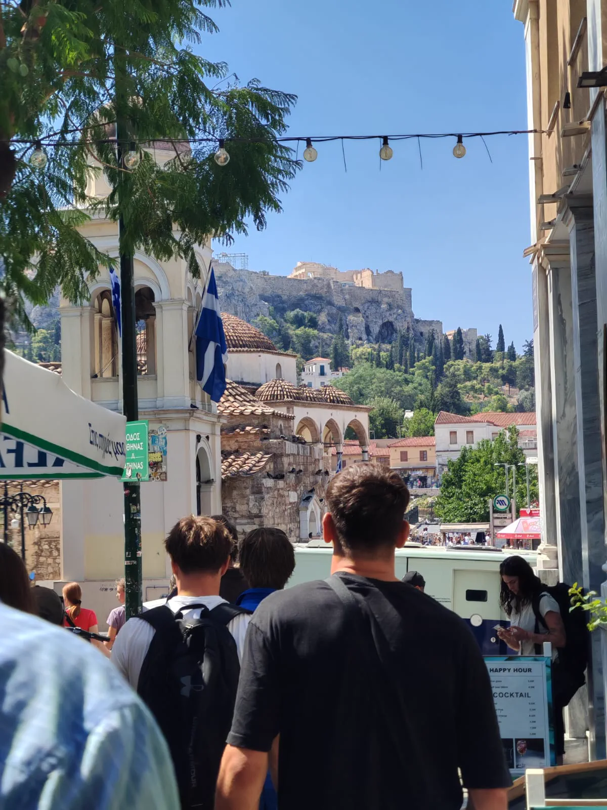 Crowds in Monastiraki, Athens, with the Acropolis and the Tzistarakis Mosque rising behind