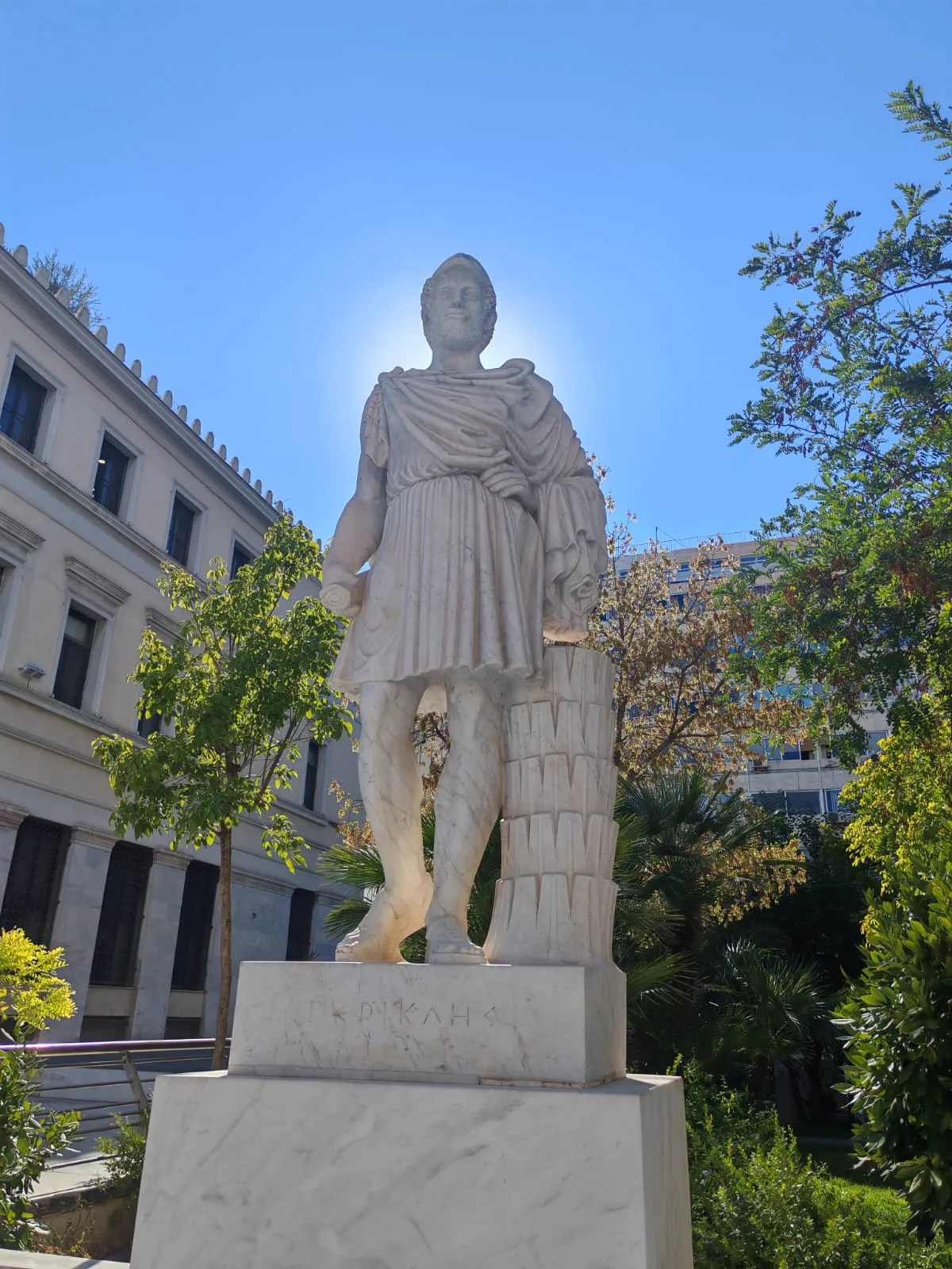 Marble statue of Pericles against a clear blue sky in central Athens
