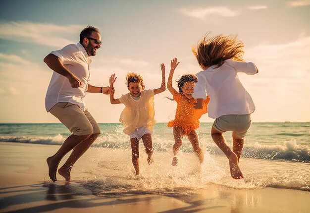 Family jumping and splashing together in the shallow waves at the water's edge