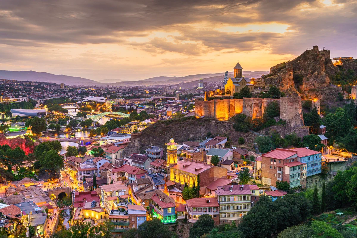 Tbilisi's old town and Narikala fortress lit up at dusk, Georgia