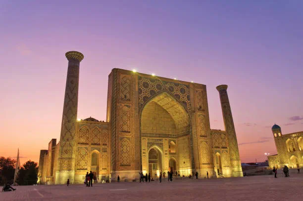 The tiled madrassas of the Registan in Samarkand lit up at dusk